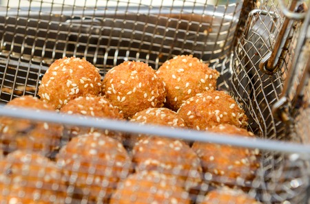 ruddy crispy cheese balls with spices in a metal gridの写真素材