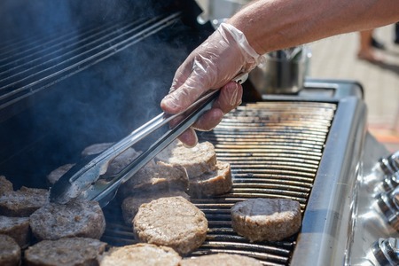 cooking steaks on a hot grill in a summer dayの写真素材