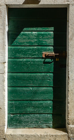 an old green ragged shabby wooden doorの写真素材