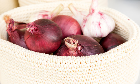 the red onions in a wicker basket close-upの写真素材