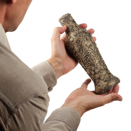 antique vase in the hands on a white backgroundの写真素材