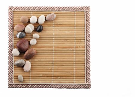 Decorative stones are on the surface of a bamboo rug. Isolated close up の写真素材