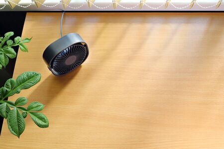 Small usb fan on the table in soft rays through the blinds, with copy spaceの写真素材