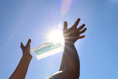 Hands are directed to the sky and the light of the sun in order to be free from restrictions imposed...