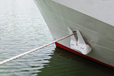 Close-up of waterline and anchor of the ship, mooring line over water