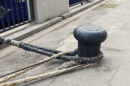 mooring bollard with heavy duty mooring ropes on the embankment of the pier