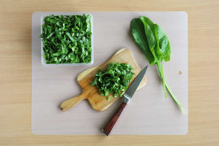Sorrel salad sliced on cutting board and knife on table, vitamins for vegetarian, In flat layの写真素材