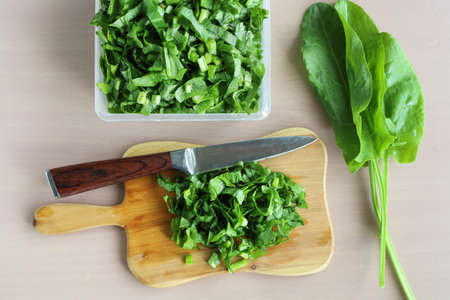 Sorrel salad sliced on cutting board and knife on table, vitamins for vegetarian, In flat layの写真素材