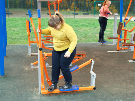 Plump child girl playing outdoor sports street simulators