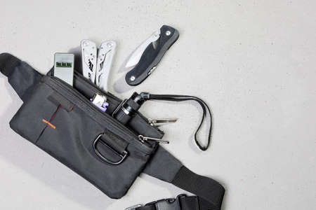 Wearable set for survival and tourism, every day carry, in flat lay on gray background, with copy spaceの写真素材