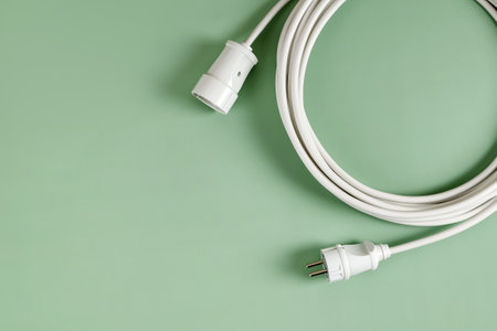 Long Wire Delivery Energy Extension Socket, Volt Energy Connecting Devices, On Green Background With Copy Spaceの写真素材