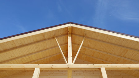 Construction of wooden terrace roof on blue sky background with copy space