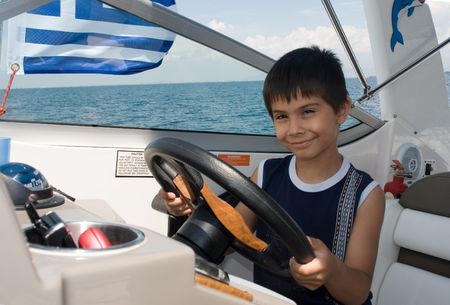 Young boy prentents that he is driving a motor-boatの写真素材