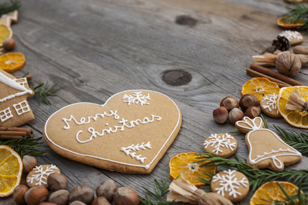 Heart shaped Christmas gingerbread with white icing, on wooden backgroundの写真素材