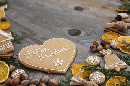 Heart shaped Christmas gingerbread with white icing, written in Hungarian, on wooden backgroundの写真素材