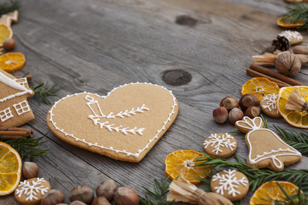 Heart shaped Christmas gingerbread with white icing, on wooden backgroundの写真素材