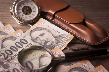 Money , retro clock, magnifying glass and pen case on a wooden table - Time is money conceptの写真素材