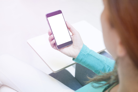 Woman hand holding contemporary modern smartphone. Visual effects. Blank display replaceable with needed design.Vertical mockupの写真素材