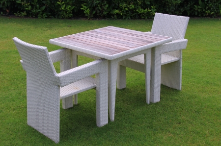 Table and chairs on a green lawn in the open airの写真素材