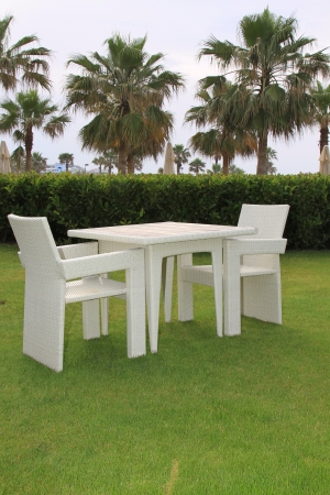 Table and chairs on a green lawn in the open airの写真素材