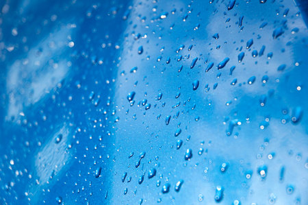 Drops on blue car mirror building with windowsの写真素材