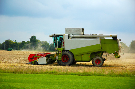 Combine harvester at work harvesting a field of wheat.の写真素材