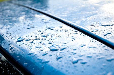 Drops on blue car mirror sky as a backgroundの写真素材