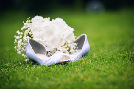 wedding shoes with wedding rings and bouquetsの写真素材