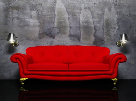 there is a red sofa and the two sconces on the dirty backgroundの写真素材