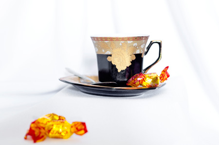 a cup and the candy on the tableの写真素材