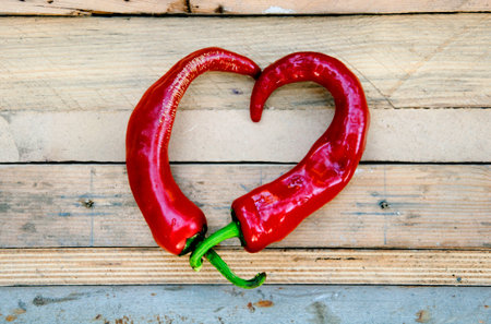 two red peppers on the wooden table (corrected)の写真素材