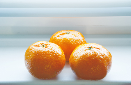 three ripe tangerine on the tableの写真素材