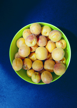a Lots of apricots in a salad plate, top viewの写真素材