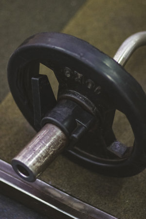 Close-up of a Heavy Weightlifting Plate Resting on a Gym Floor, Showcasing the Strength and Dedication Required for Fitness Training