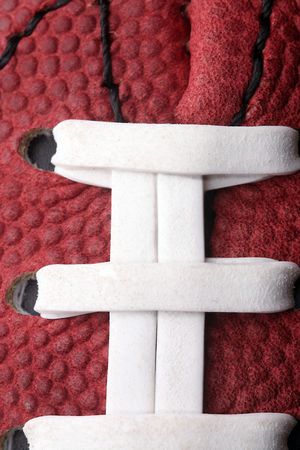 Macro view of a American football, pig skin, sports. Upclose vertical view. Textures and patterns with white lacing.の写真素材