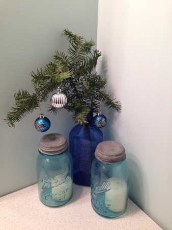 Christmas ornaments on evergreen in glass jar with white candles in antique mason jars の素材
