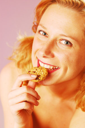 An young blond woman with a biscuitの写真素材