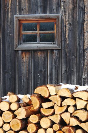 A pile of wood near wall in winterの写真素材