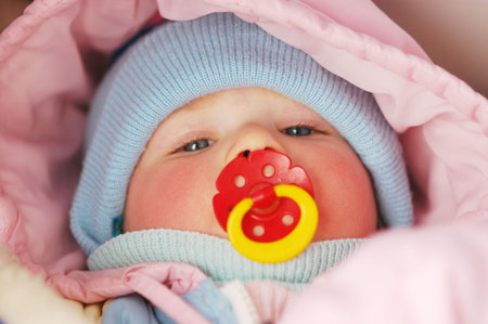 Baby with soother sleeping in pram