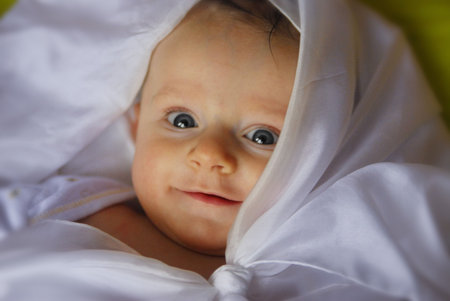 A little baby wrapped into a white sheet