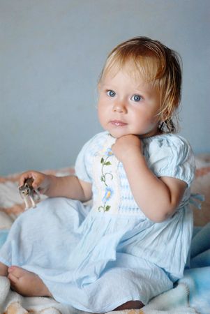 A little blonde girl in white clothesの写真素材