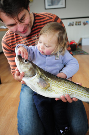 The father and his little daughter with fish.