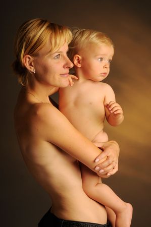The undress mother with little child on brown backgroundの写真素材