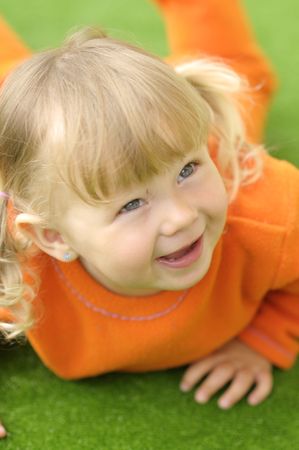 The portrait of little happy girl with pigtails in orange clothesの写真素材