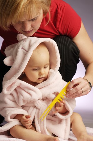 The portrait of little beautiful girl in pink bathrobe on light backgroundの写真素材