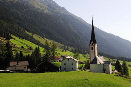 The small village with white church in Austria's mountainsの写真素材