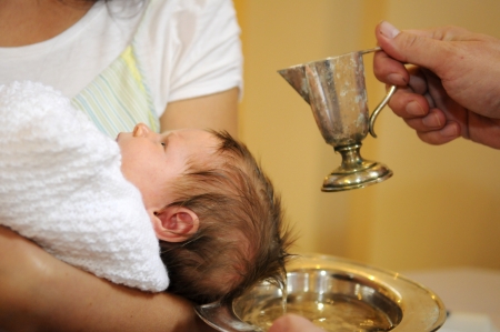 The baptism of little baby with blessed water from iron jugの写真素材