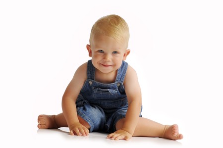 The little blonde boy in blue jeans on isolated backgroundの写真素材