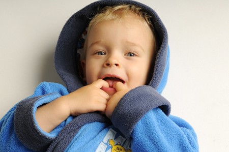 Little smilling blonde boy in bathrobe on white backgroundの写真素材