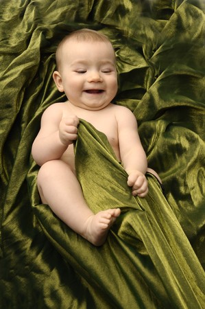 Smilling little baby on green blanket の写真素材